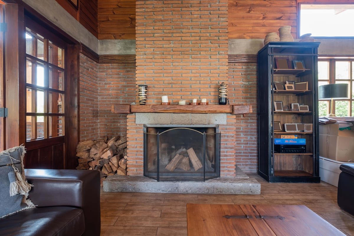 Salón con chimenea de ladrillo y biblioteca